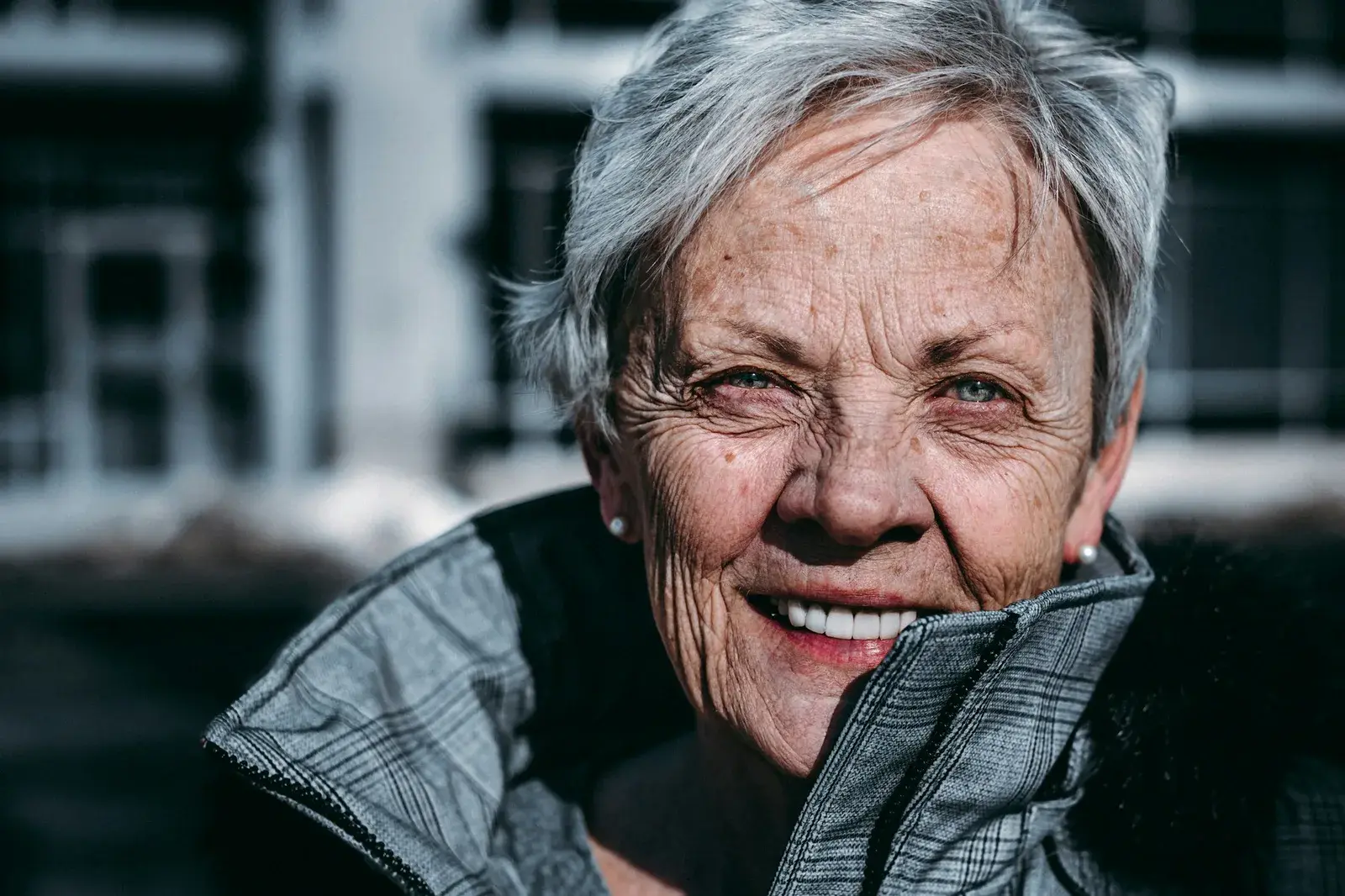 Donna anziana che sorride, denti naturali in evidenza (foto Unsplash)